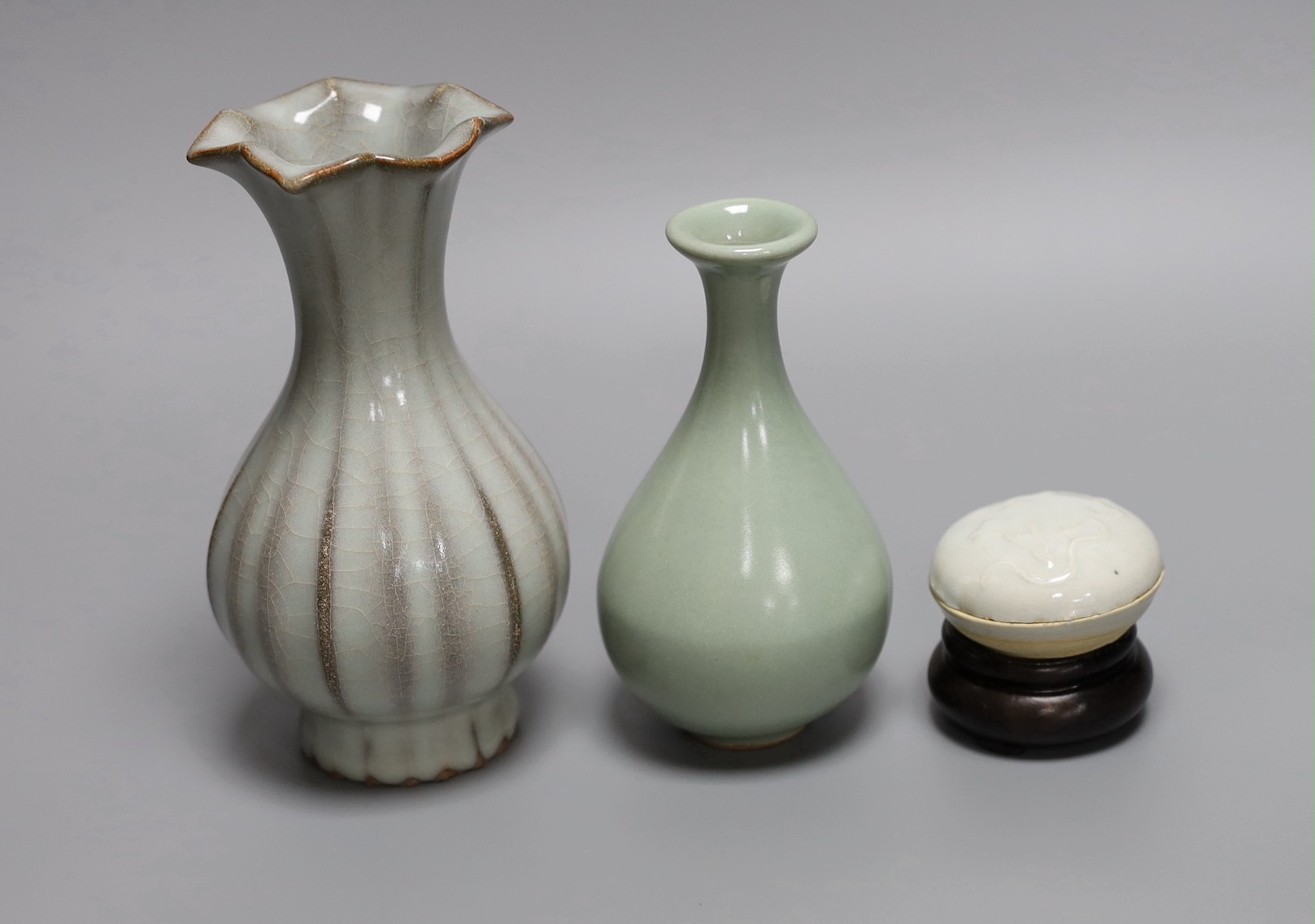A Chinese celadon ground bottle vase, a similar crackle glazed vase, a paste box with cover and stand, tallest 16cm